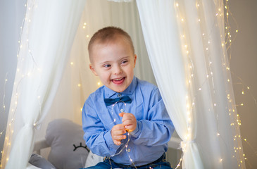 Portrait of a boy with Down Syndrome. Genetic and mental illness in a disabled child.