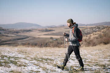 Naklejka premium Side view of tourist walking on field with mountain view