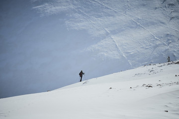 Athlete man walking through the snow with snowshoes, he's alone