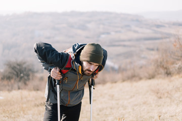 Fototapeta na wymiar Tired hiker man resting on hiking poles