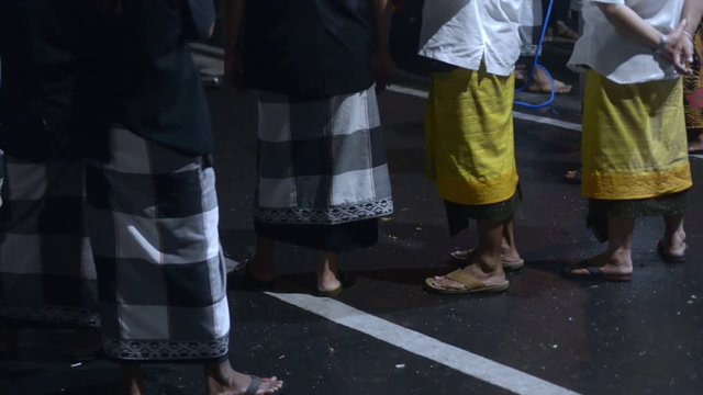 abstract shot of security guards, indonesian police protecting safety on asphalt road at night. national festival show. people spectators. closeup of legs and skirt
