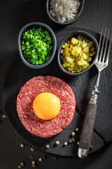 Tasty beef tartare with yolks, chives and pepper