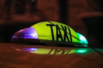Detail of yellow taxi sign on top of a car