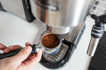 Guy prepare delicious aromatic coffee in a coffee machine. A simple way to make coffee