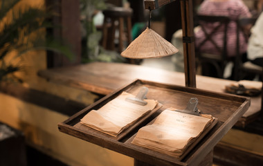 Typical Vietnam. Stylized menu stand in one of the restaurants in Hoi An, Vietnam. The menu is illuminated with a light bulb stylized as a traditional Vietnamese sun hat.