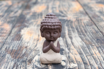 Morning meditation. Little buddha or monk figurine doing yoga exercises