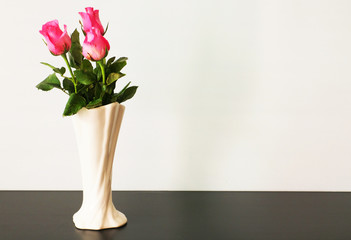 Pink roses in a classic vase on white background