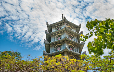 Ancient Buddhist pagoda against the blue sky and clouds. Vietnam.