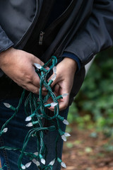 man holding cords of lights ready to decorate for the holiday season