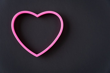 Pink heart outline on a black background as a background
