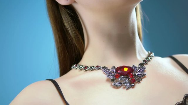 beautiful young girl wears a necklace. blue background