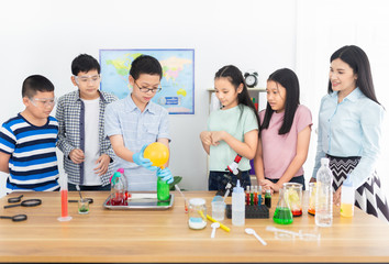 smart asian students learning to experimentation with female teacher in classroom, they explaining...