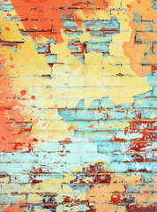 Brightly colored orange yellow and aqua turquoise paint splatter digital painting on brick wall background texture with empty space as a grunge retro colored template