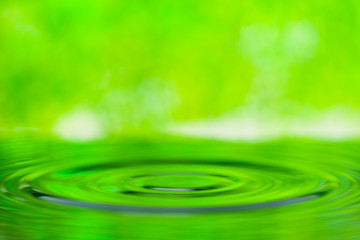 Naklejka na ściany i meble 水面に落ちる滴と爽やかな緑背景