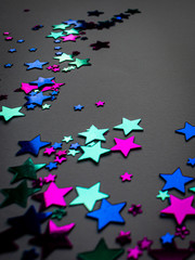 Bright stars on grey background, pink, blue and teal