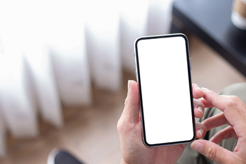 Mockup image blank white screen cell phone.man hand holding texting using mobile on desk at coffee shop.background empty space for advertise text.people contact marketing business,technology 