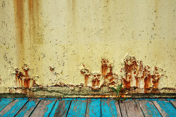 Rusty metal wall, old sheet of iron covered with rust with multi-colored paint. Large cracks. Оld...