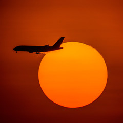 Naklejka na ściany i meble Silhouette of passenger airplane with the morning sunrise background