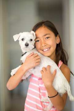 Little Girl Giving Her Dog A Big Hug.