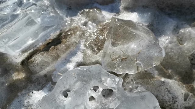 Background of ice chunks on a sandy beach.