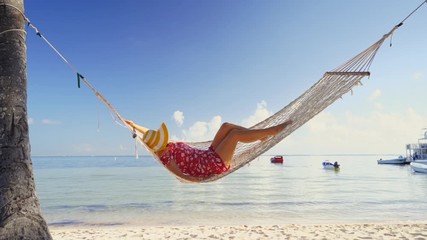 Girl relaxing in a hammock on tropical island beach. Summer vacation in Punta Cana, Dominican Republic