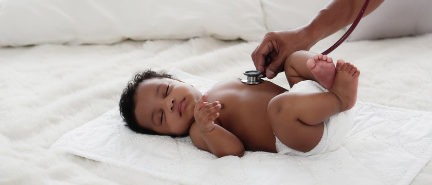 african american baby girl being health checkup with stethoscope