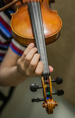 Close up of hand on throat of violin
