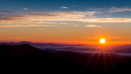 Sun peaks over the mountain peaks of the Blue Ridge Parkway