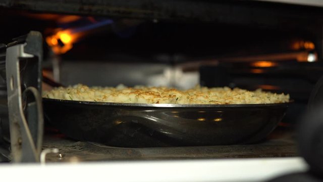 Putting A Pan With Vegan Shepherds Pie In An Oven For Baking - Close Up