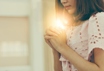 Beautiful asia woman praying inside a church to god  blessing to wishing have a better life.