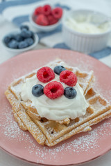 Fresh sugar waffles with castor sugar and berries