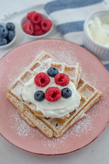 Fresh sugar waffles with castor sugar and berries