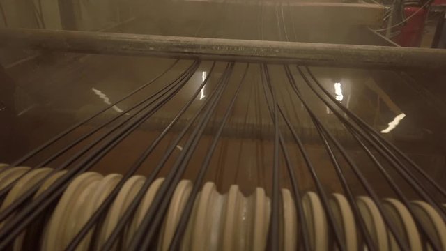 Hot plastic spaghetti cooling after extrusion. Polymeric industrial processing.