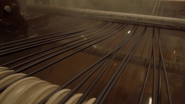 Hot plastic  black spaghetti cooling after extrusion. Polymeric industrial processing.