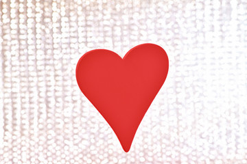 Heart. One red wooden heart hangs on a silver shiny background. Valentine's day, February 14.