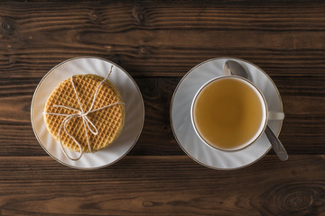 Obraz na płótnie Canvas Homemade waffles and tea with cinnamon and lemon on a wooden table. Flat lay.