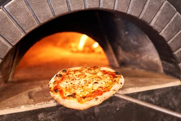 Foto op Aluminium Gebakken smakelijke margherita pizza in traditionele houtoven in het restaurant van Napels, Italië. Originele Napolitaanse pizza. Roodgloeiende kolen. © malkovkosta