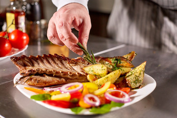 the chef prepares in the restaurant. Grilled rack of lamb with fried potatoes and fresh vegetables
