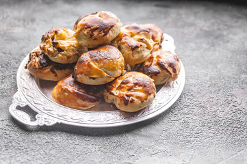 Obraz na płótnie Canvas Sweet homemade chocolate-nut buns on a silver platter.