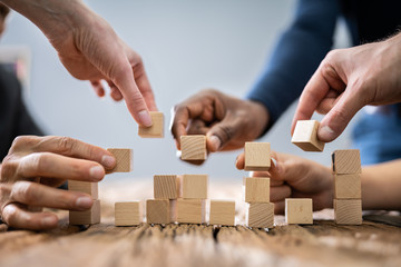 Businesspeople Arranging The Wooden Blocks