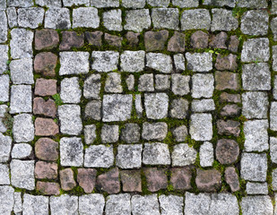 Wall of stone blocks. Paved walkway made of stones. Granite brickwork. Mosaic.