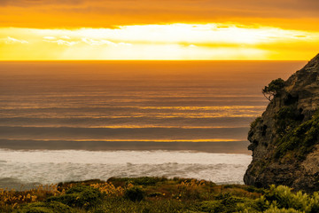 Evening view of Tasman sea coast with long surfing waves in background