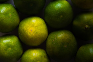 Green tangerines. Fancy fruits. Background