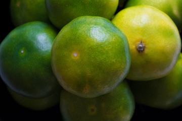 Green tangerines. Fancy fruits. Background