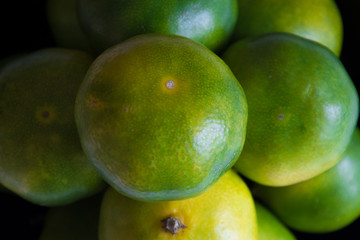 Green tangerines. Fancy fruits. Background