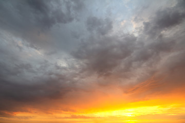 Sunset sky covered with orange puffy clouds in the evening.