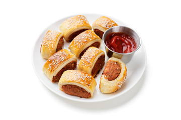 Delicious homemade sausage rolls served with tomato sauce isolated on white background