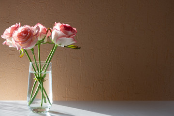 roses in vase on wooden table