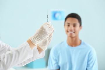 Doctor with vaccine in syringe prepared for injection in clinic