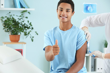 Doctor vaccinating teenage boy in clinic
